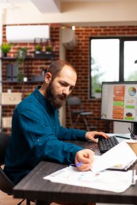 Businessman sitting at desk analyzing business paperwork working at management presentation