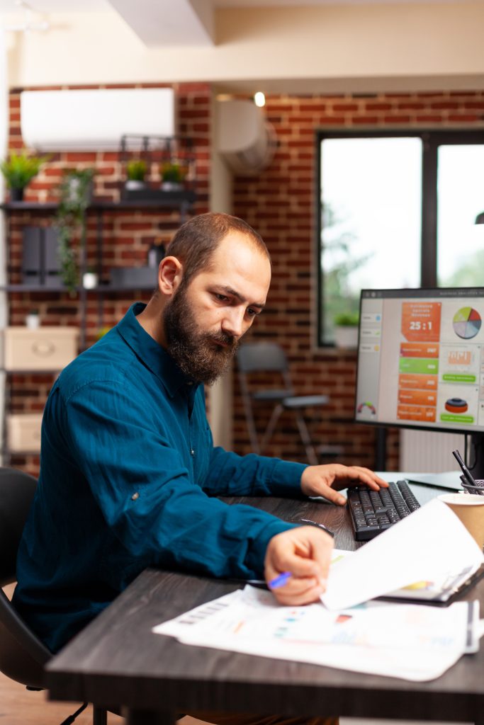 Businessman sitting at desk analyzing business paperwork working at management presentation