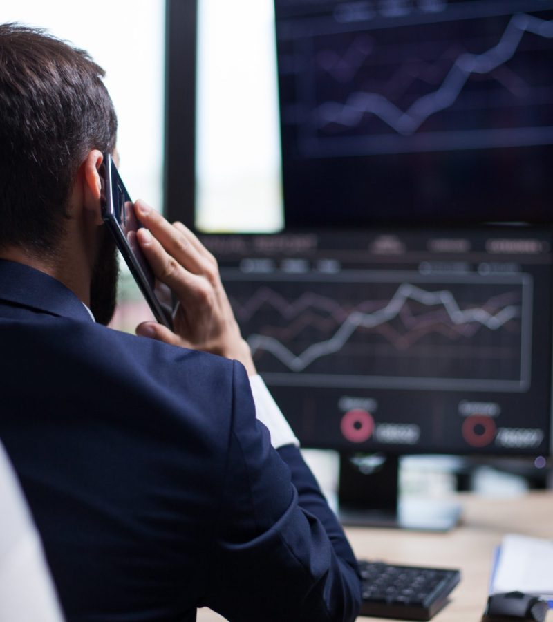 Back view of young business bearded man having a phone call with his CEO