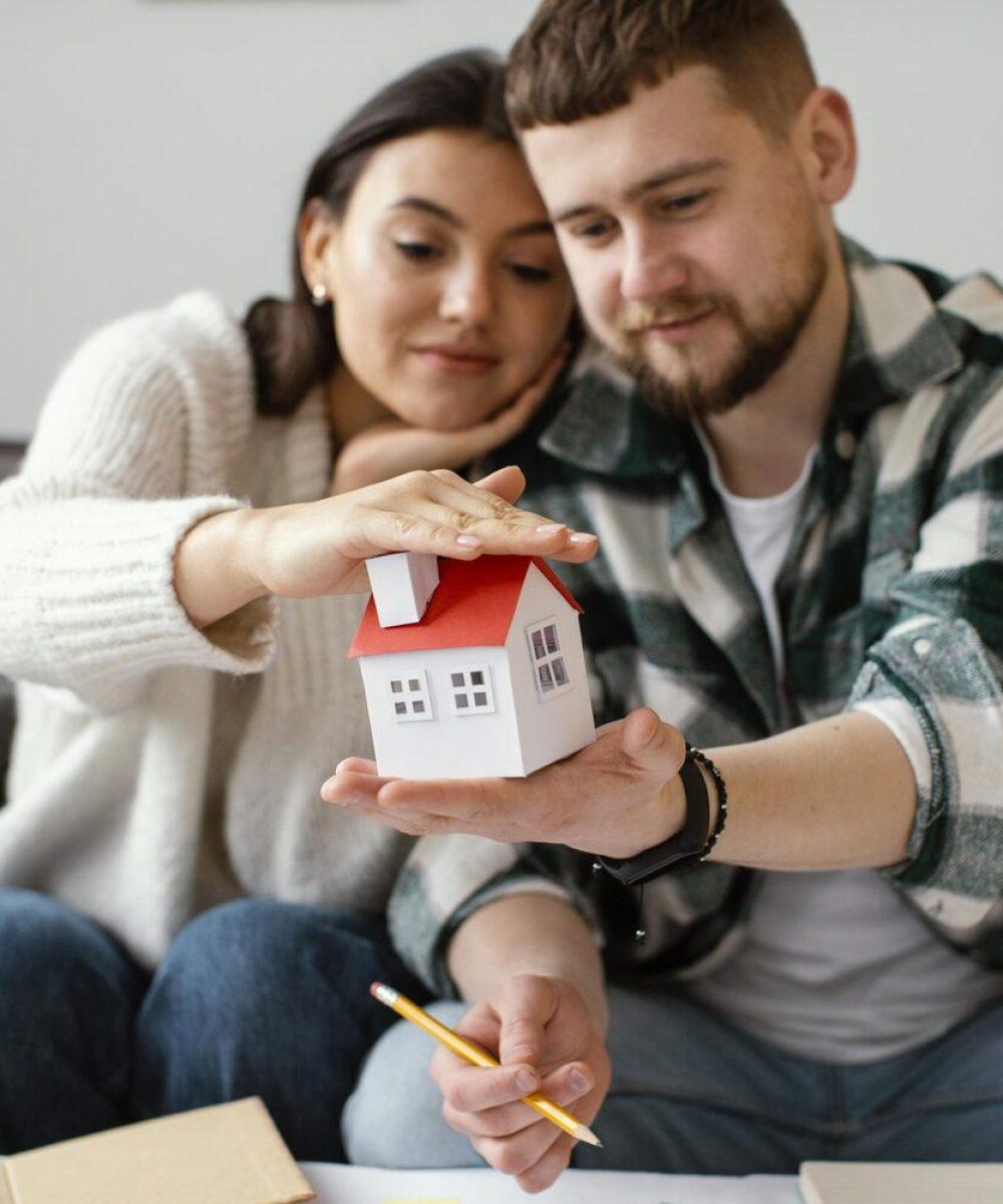 couple-holding-small-house-medium-shot