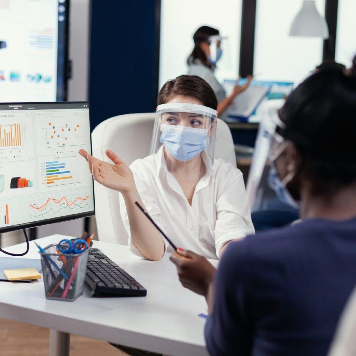 Manager wearing face mask for covid19 explaining financial graph