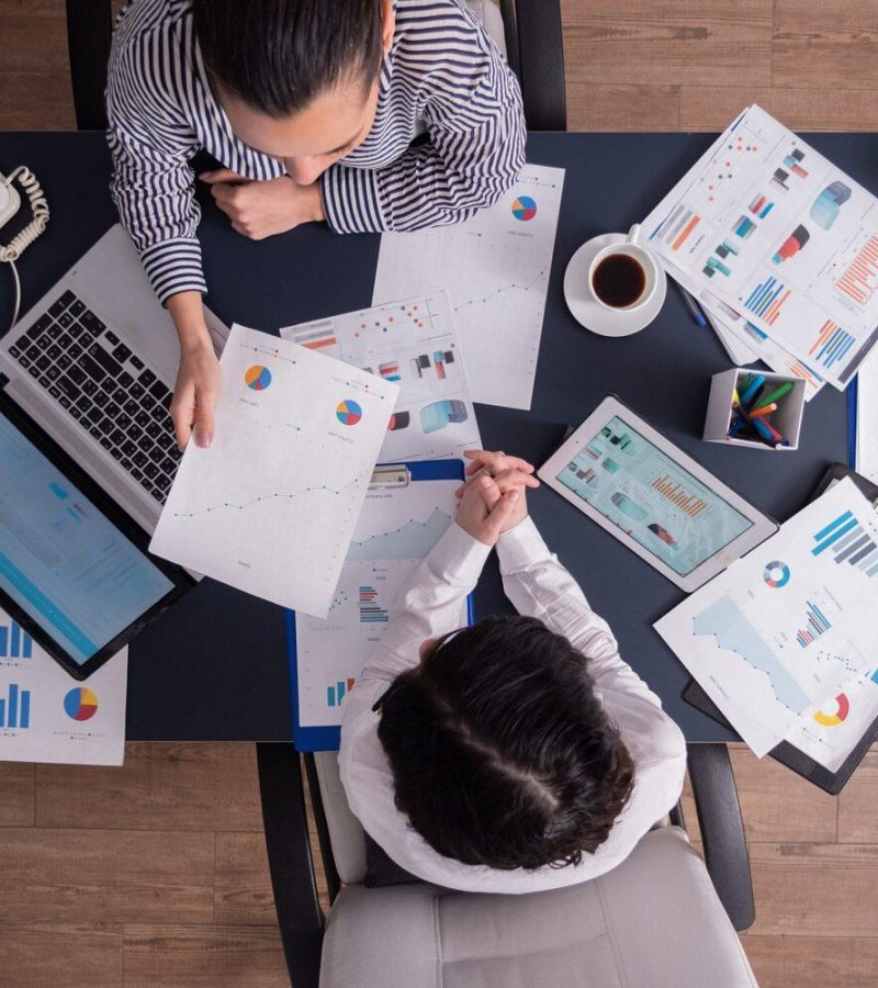 Top view of office workers meeting analyzing financial charts